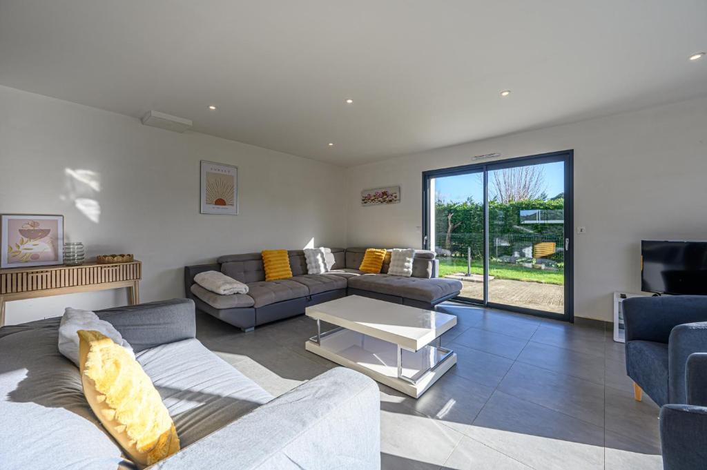 a living room with a couch and a table at Domaine de Larmor - Maison proche plages in Damgan