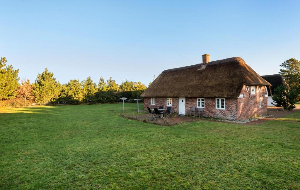 ein altes Haus mit einem Strohdach auf einem Feld in der Unterkunft 2 Bedroom Lovely Home In Blåvand in Blåvand