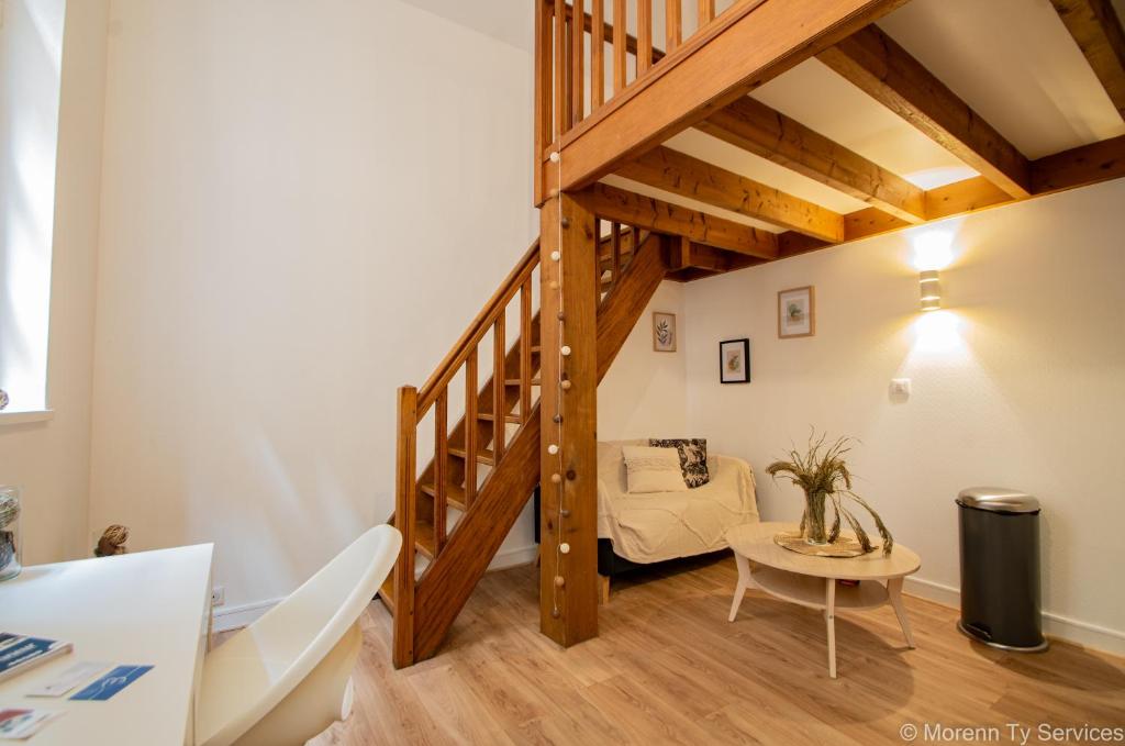 Cette chambre dispose d'un escalier avec un canapé et une table. dans l'établissement Studio calme hypercentre - Ty ar Lafayette, à Rennes