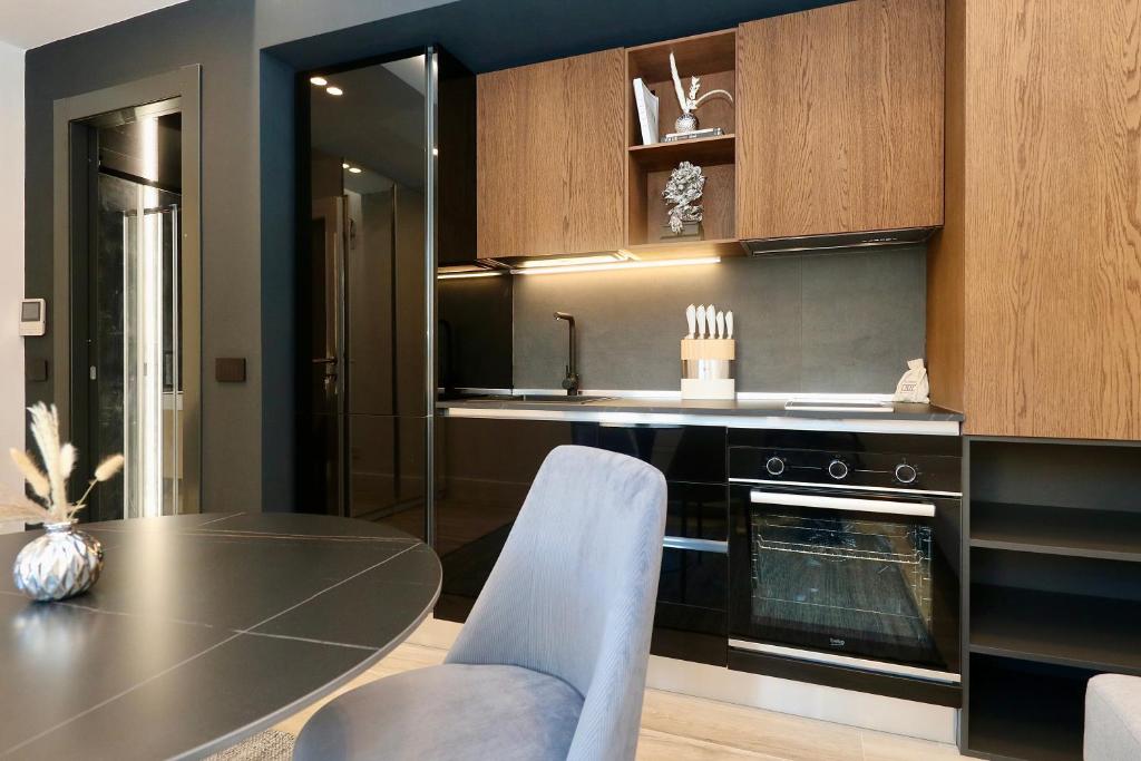 a kitchen with a dining table and a stove at Luxury studio Garibaldi - perfect for couples - fully Equipped - Historical Centre in Olbia