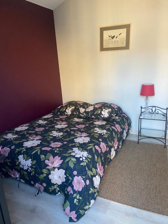 une chambre avec un lit avec une couette fleurie dans l'établissement CALME , PROCHE du Centre, Grande Terrasse, Petit déjeuner, à Bordeaux