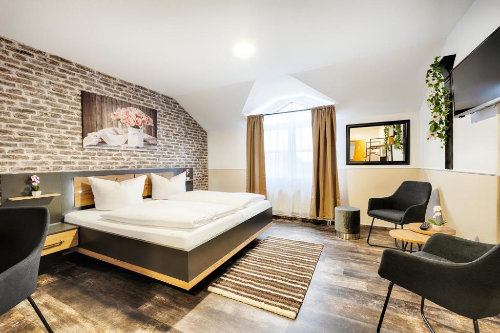 a bedroom with a bed and a brick wall at Hotel Apfelblüte in Wendorf