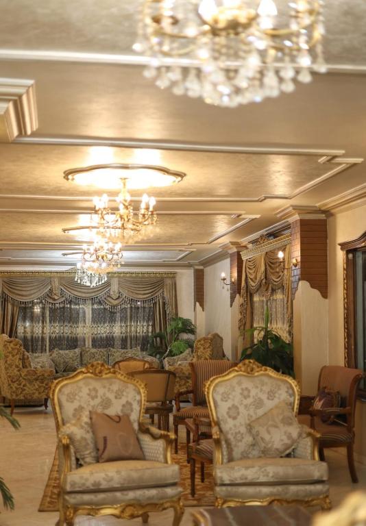 a living room with chairs and a chandelier at Royal palace in Kafr ‘Işām