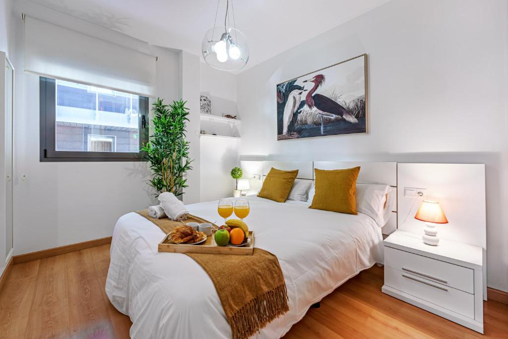 a bedroom with a bed with a tray of fruit on it at SUNSET MALAGA - Queen Victoria in Málaga