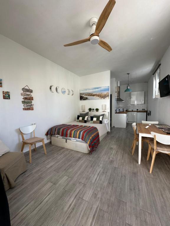 Un dormitorio con una cama y un ventilador de techo. en Calma, en Tarifa