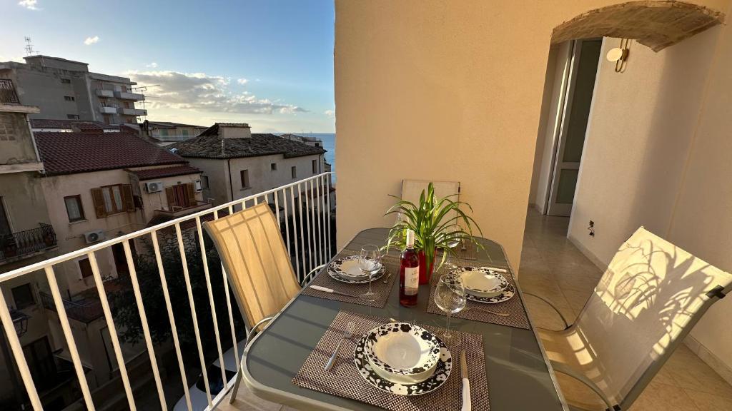 Una mesa en un balcón con vista al mar. en Tropea Vicoli Storici Rota, en Tropea
