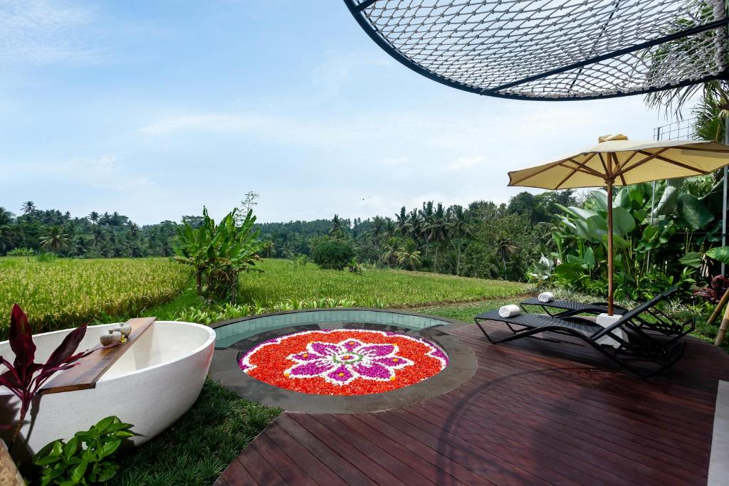 eine Terrasse mit Tisch und Sonnenschirm in der Unterkunft The Pulu Villas by GenuineHost in Ubud