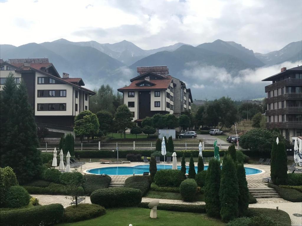 a view of a garden with a pool and buildings at ASPEN GOLF RESORT Ski & Spa RELAX APARTMENT in Bansko