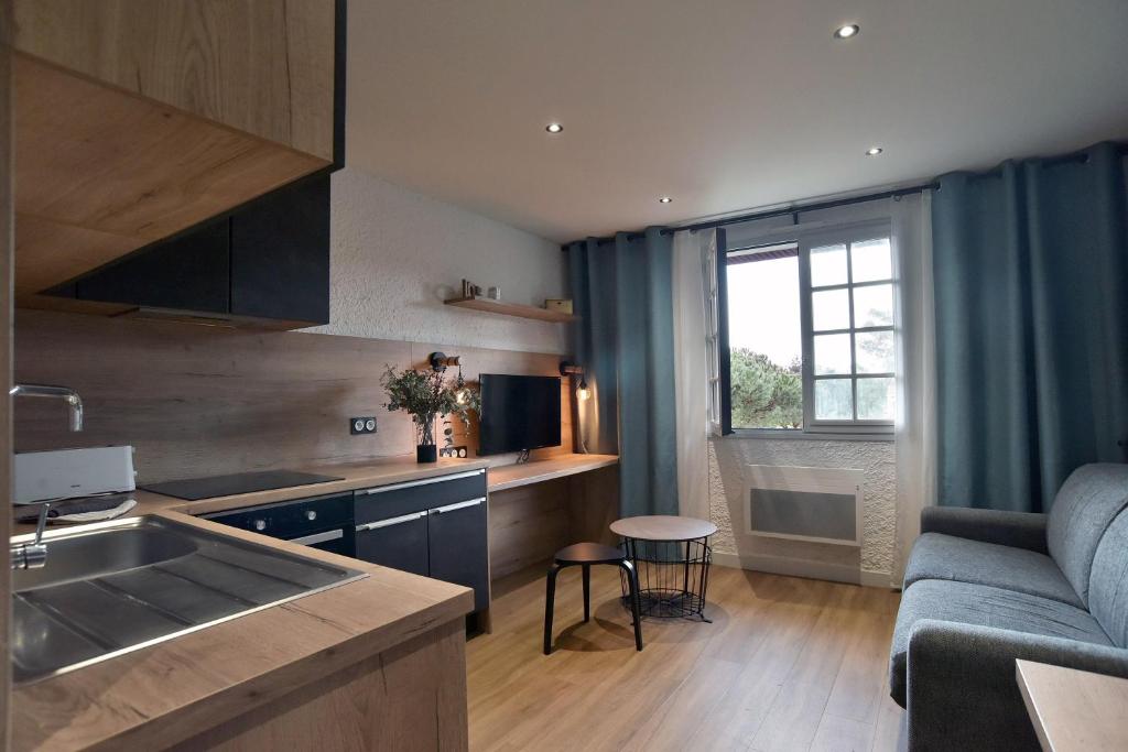 une cuisine et un salon avec un canapé et une table dans l'établissement Pierrette 12 - 200m de la plage parking privé, à Fréhel