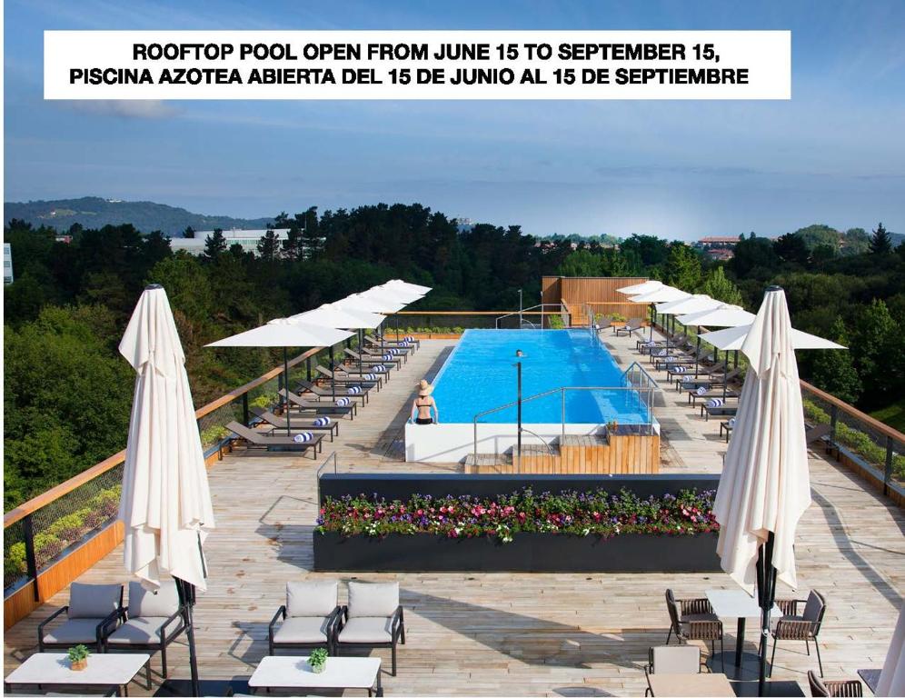 uma piscina com cadeiras e guarda-sóis num telhado em Hotel Arima & Spa - Small Luxury Hotels em San Sebastián