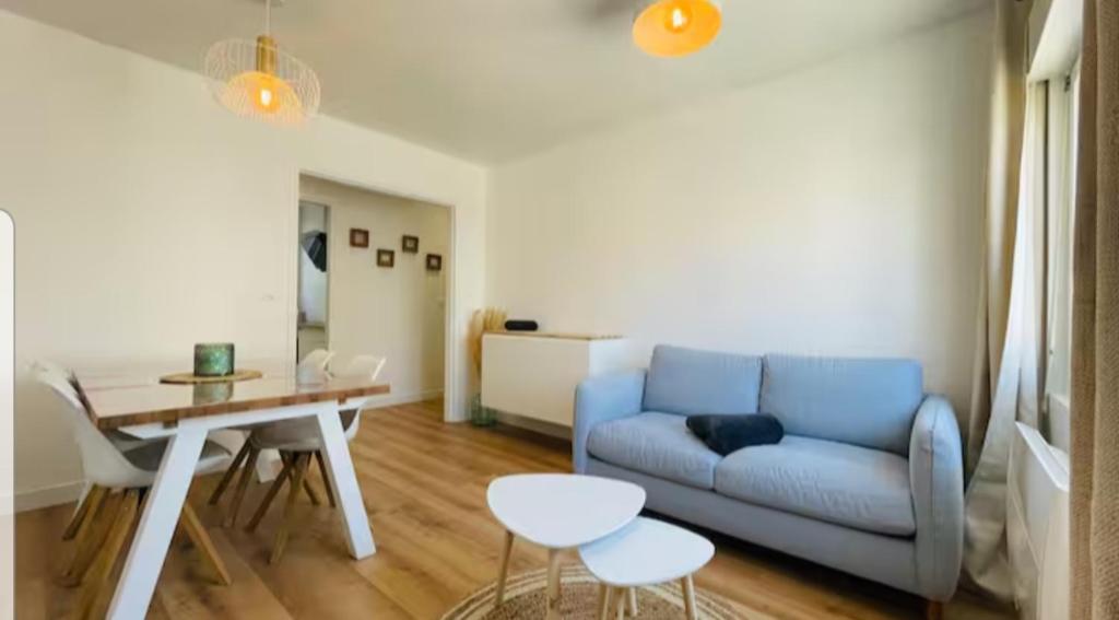 un salon avec un canapé bleu et une table dans l'établissement PAROGA appartement à 100m de la plage, à Merlimont