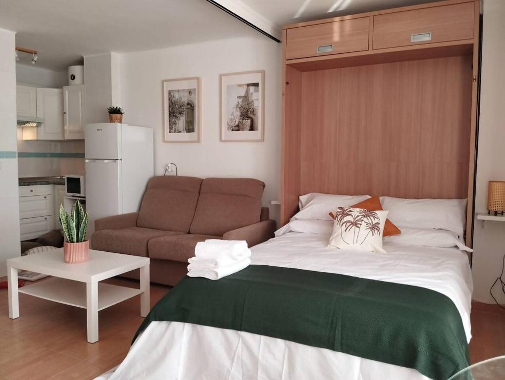ein Schlafzimmer mit einem großen Bett und einer Couch in der Unterkunft Torrox Costa Loft Playa Wi-Fi Paseo Marítimo in Torrox