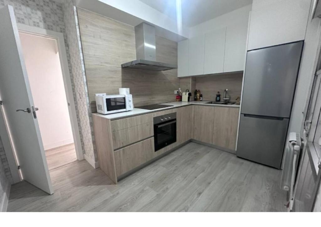 a kitchen with a refrigerator and a microwave at Villa Artista home in Pontevedra