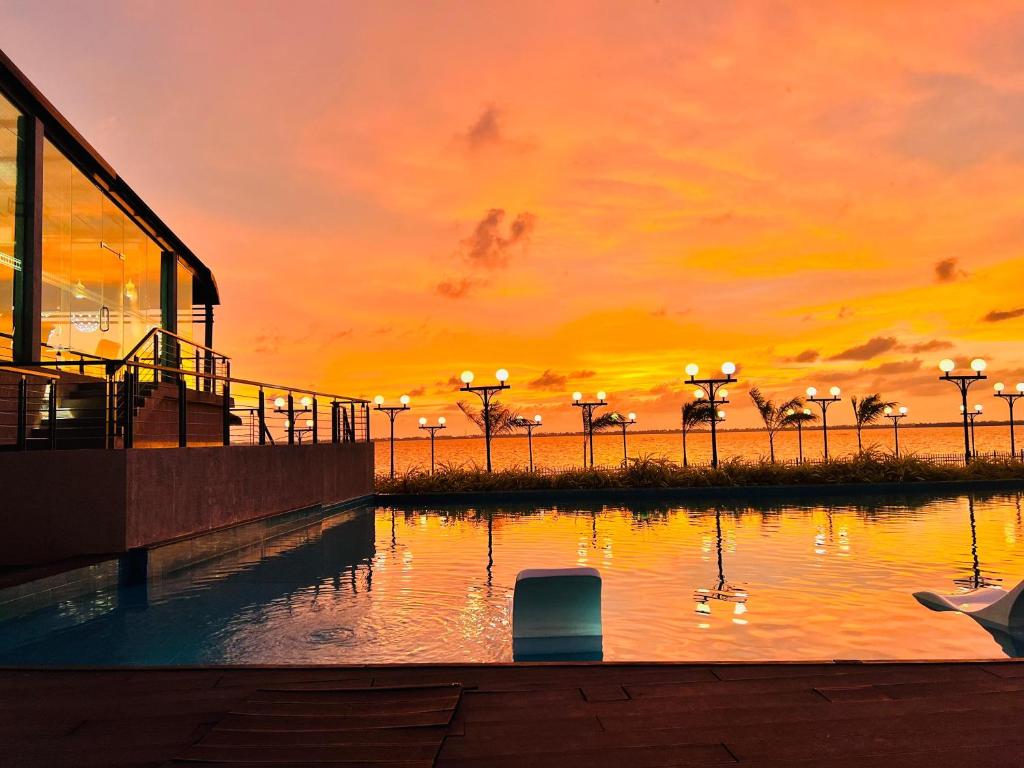 ネゴンボにあるGrandeeza Hotel by Galisonの水中のアヒルと池に沈む夕日
