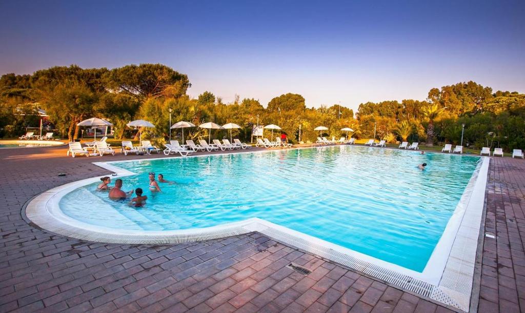 une grande piscine avec des gens dans l'eau dans l'établissement Feriendorf Le Tamerici Mobilehome Nuraghe für 6 Personen, à Marina di Cecina