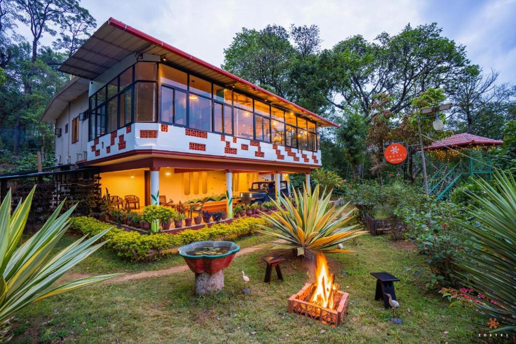 a house with a fire pit in front of it at Zostel Coorg, Madikeri in Madikeri