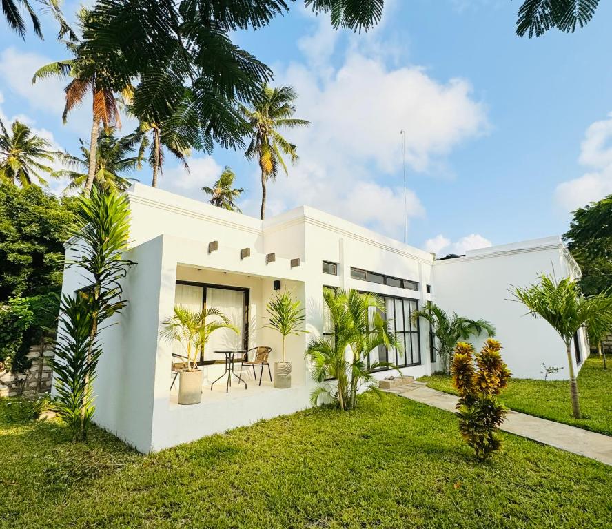 ワタムにあるWatamu Ochre Villasのヤシの木と芝生の白い家