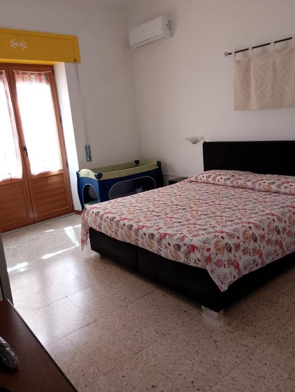 a bedroom with a bed and a sliding door at Affittacamere Casa Chiara in SantʼAntìoco