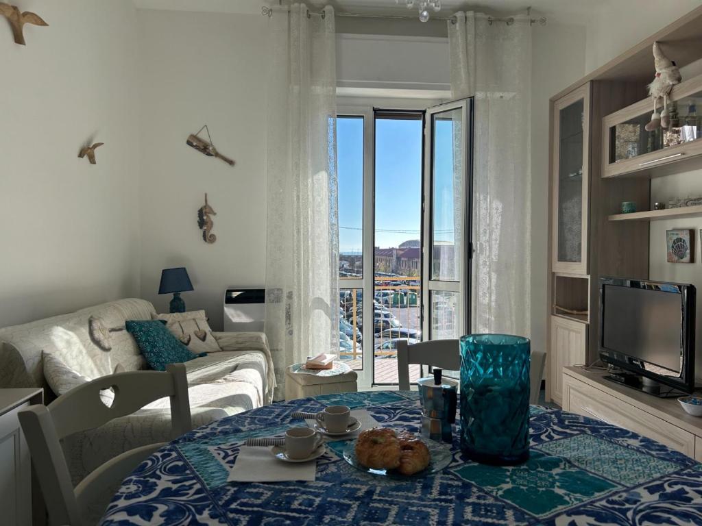 a living room with a table and a tv at Oasi Serena in Finale Ligure
