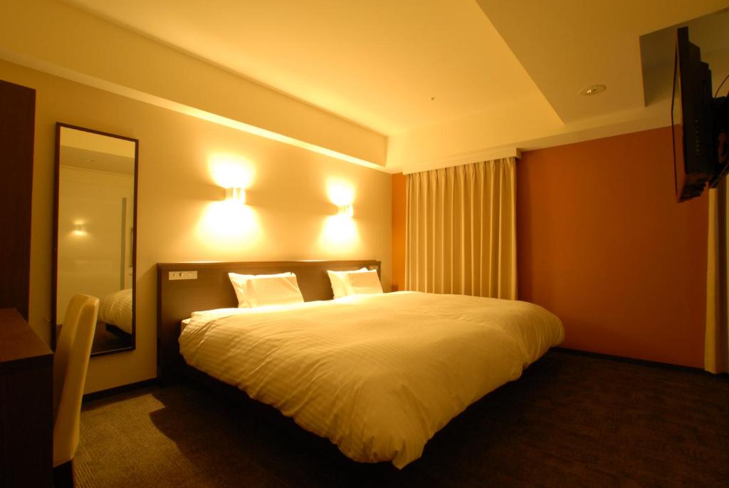 Postel nebo postele na pokoji v ubytování AB Hotel Kanazawa