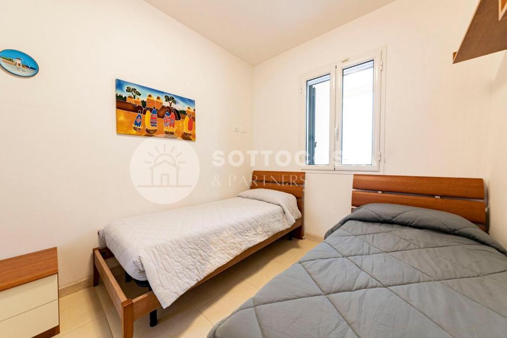 ein Schlafzimmer mit zwei Betten und einem Fenster in der Unterkunft Villa con piscina Maracuja - Torre Dell'Orso in Torre dell'Orso