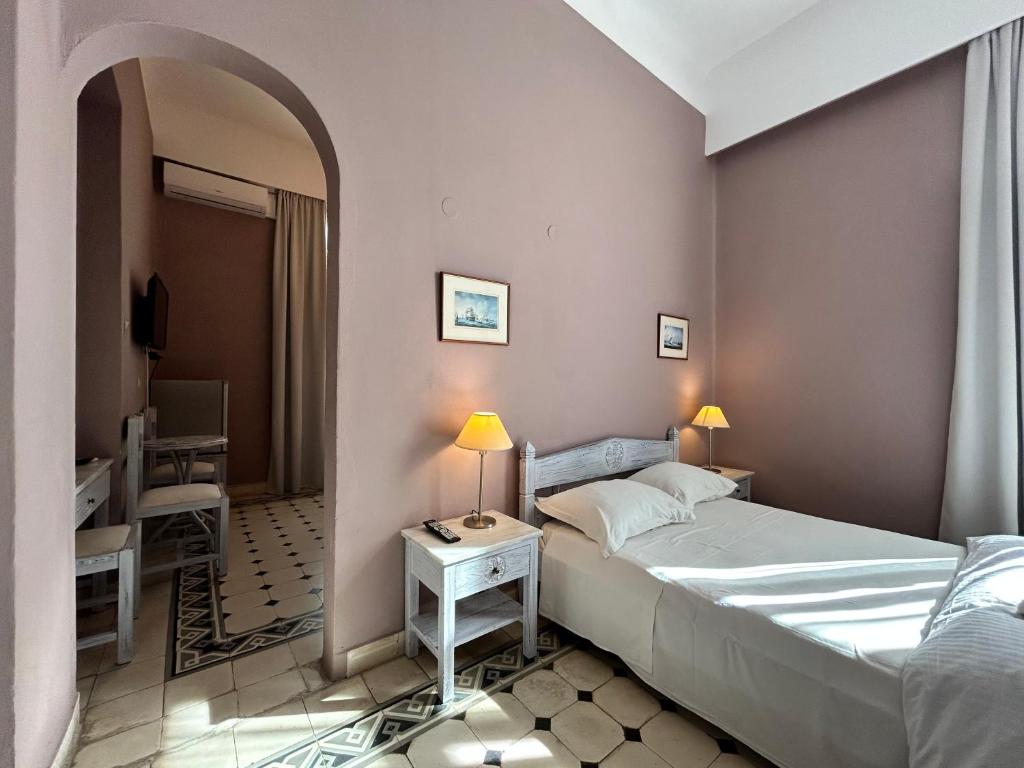 sypialnia z łóżkiem i stołem z lampką w obiekcie Tinion Urban Hotel w mieście Tinos