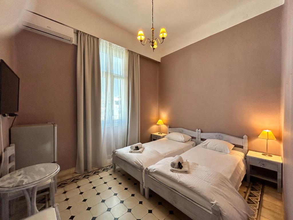 pokój hotelowy z dwoma łóżkami i oknem w obiekcie Tinion Urban Hotel w mieście Tinos