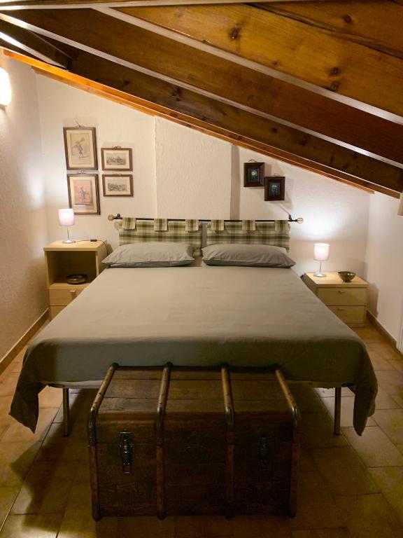 a bedroom with a bed with a trunk on it at Appartamento mansardato centrale Limone Piemonte in Limone Piemonte