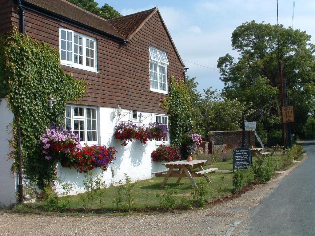 a house with flowers on the side of it at Two Sawyers in Pett