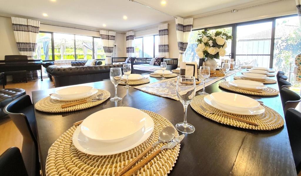 a dining room with a long table with plates and silverware at Capel Sound OASIS Getaway in Capel Sound