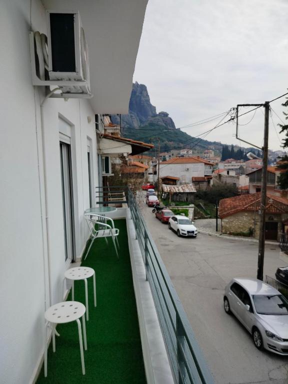 a balcony with tables and chairs and a street at GRAND HOUSE METEORA in Kalabaka