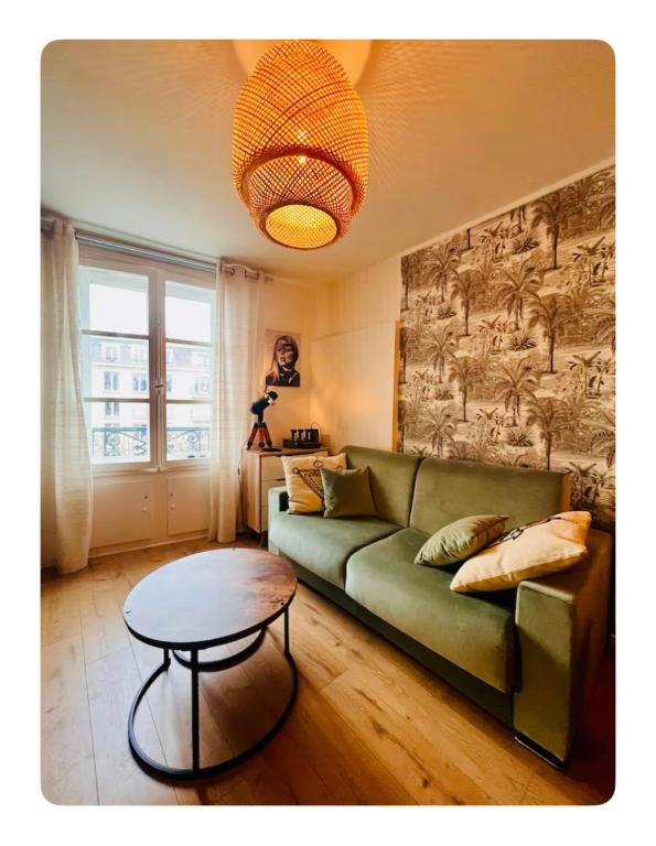 un salon avec un canapé vert et une table dans l'établissement Studio Versailles, à Versailles