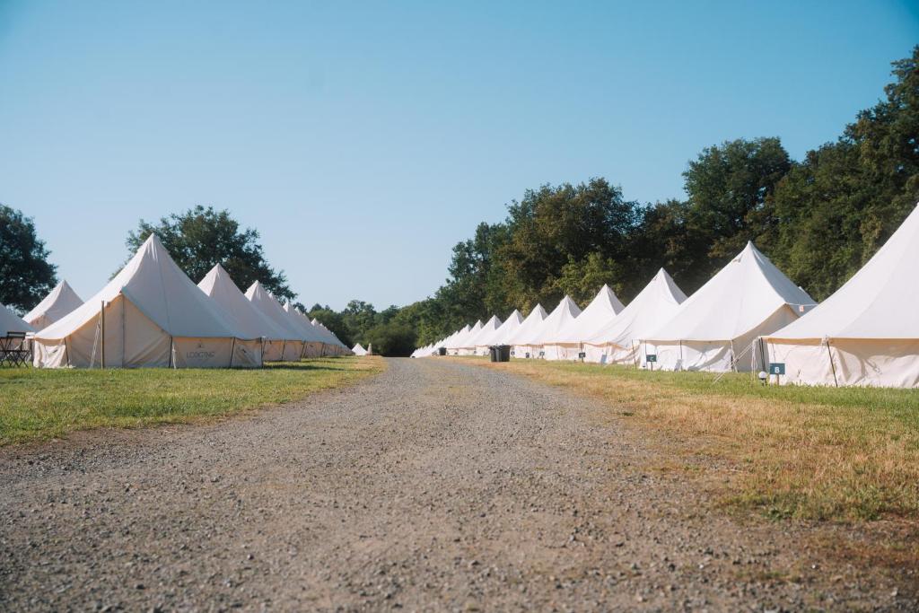 ルマンにあるSilver - Glampingの未舗装道路に並ぶ白いテント
