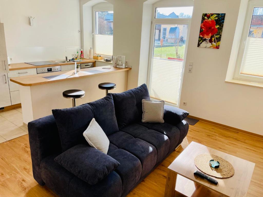 a living room with a couch and a kitchen at STADTOASE Frankenberg - Adults Only - Moderne Apartments mit Balkon nahe Chemnitz - Monteure willkommen in Frankenberg