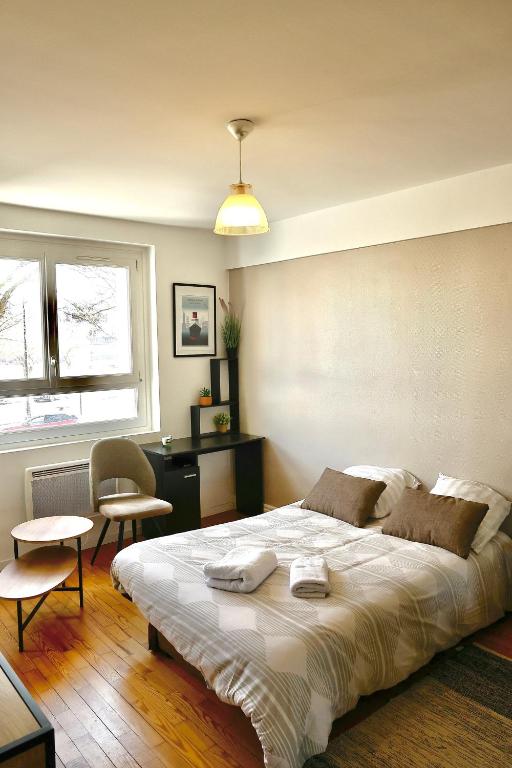 une chambre avec un grand lit et un bureau dans l'établissement Studio Plage, à Le Perrey