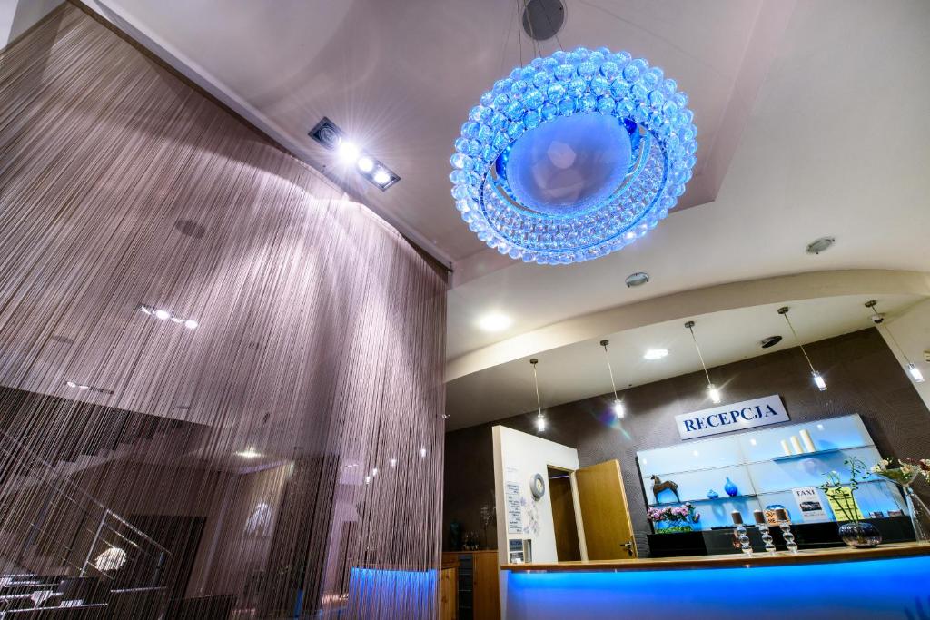 a blue chandelier hanging from the ceiling of a store at Hotel Nowy Dwór in Trzebnica