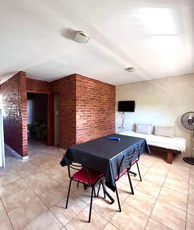 a living room with a table and a bed at Casa Nuova - Depto SEIS in Villa Nueva