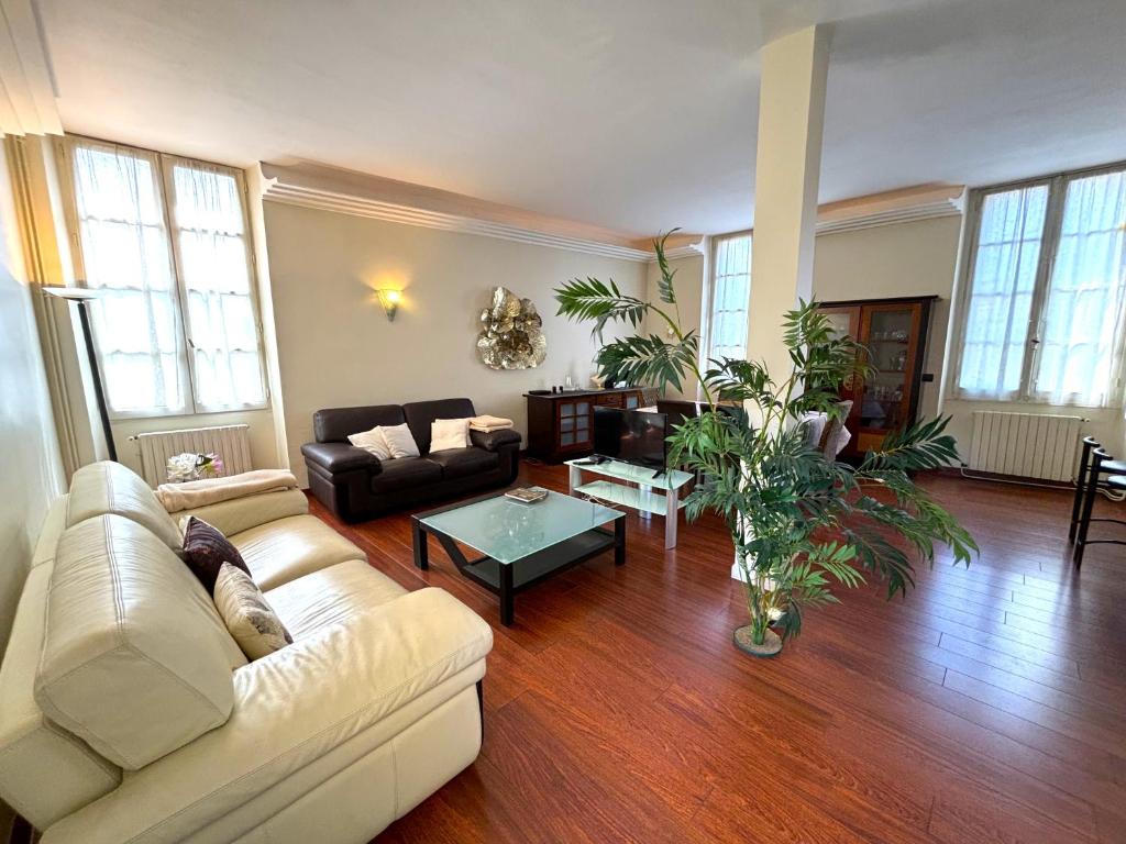 un salon avec un canapé et une table dans l'établissement SPACIOUS FLAT WITH AC & 33M² TERRACE IN SARLAT, à Sarlat-la-Canéda