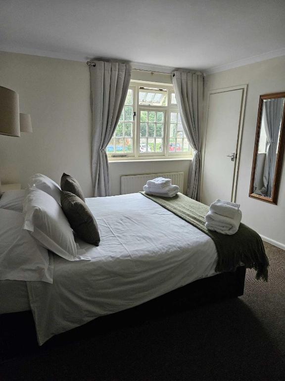 a bedroom with a large bed with pillows and a window at The Barford Inn in Salisbury