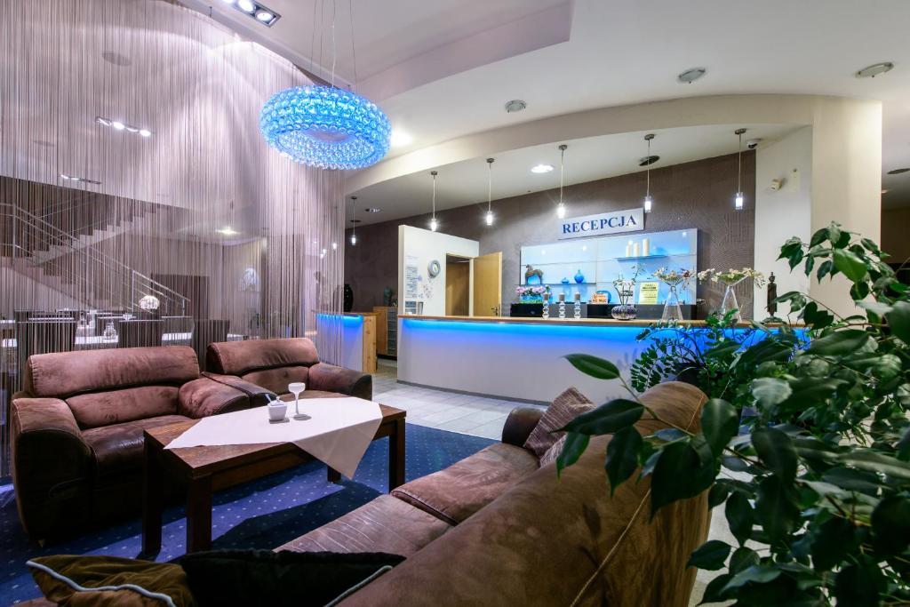 a lobby with couches and a table and a counter at Hotel Nowy Dwór in Trzebnica