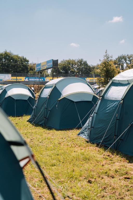 un groupe de tentes assises dans l'herbe dans l'établissement Bronze - Camping, au Mans
