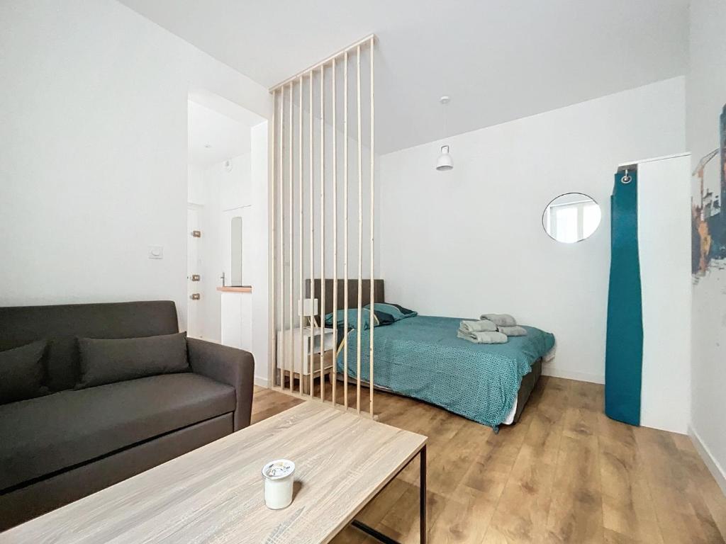 un salon avec un lit et un canapé dans l'établissement beau T1 proche gare de Nantes, à Nantes