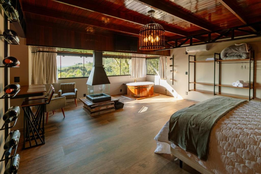 a bedroom with a bed and a desk at Pousada Bégamo - Vale dos Vinhedos l Suítes Gran Reserva in Bento Gonçalves