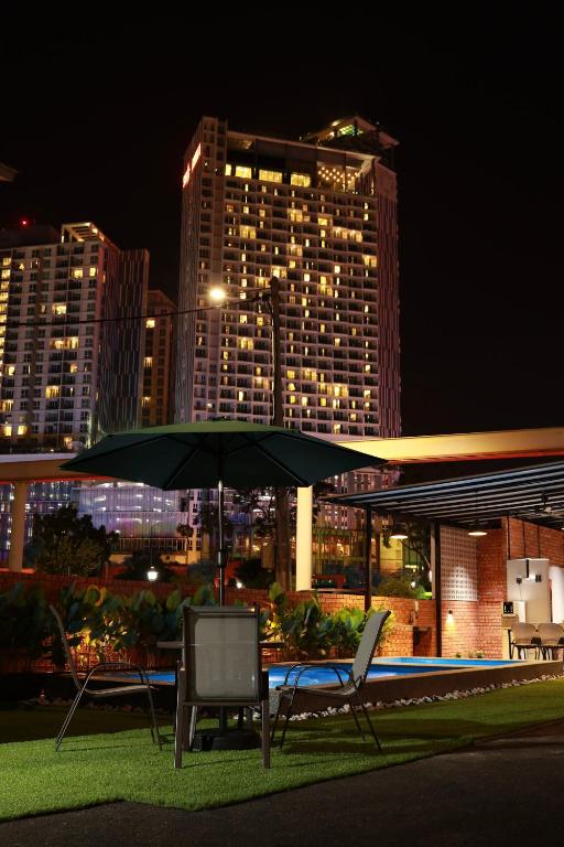 a table and two chairs under an umbrella at night at MARI Suites in Malacca