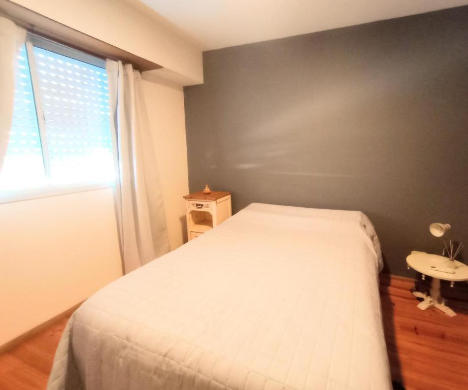 a bedroom with a white bed and a window at Duplex Echesortu a metros de la terminal in Rosario