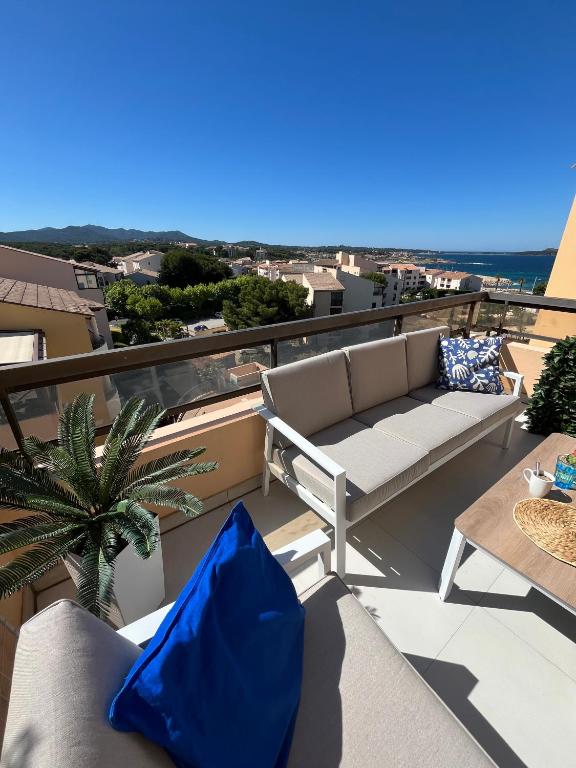 un balcon avec un canapé et une table dans l'établissement Vue 180 degrés mer-colline, plages 100m, Piscine, Box , Domaine Coudoulière Six Four les Plages, à Six-Fours-les-Plages