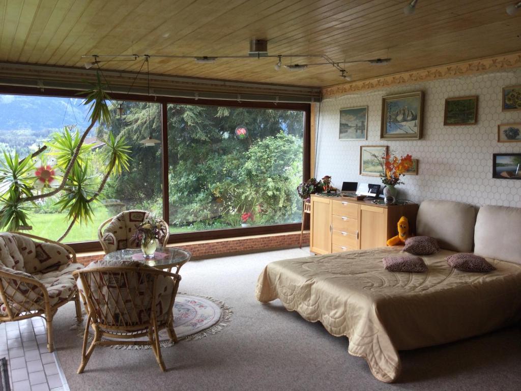 a bedroom with a bed and a large window at Pension Krüger in Seeboden