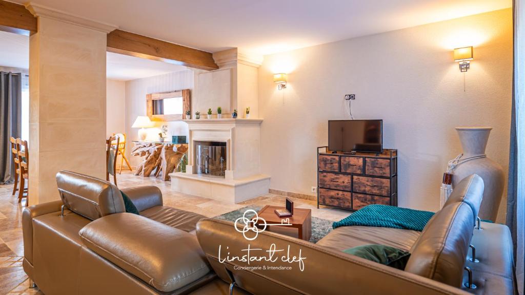un salon avec un canapé et une cheminée dans l'établissement Cocon Familial & Terrasse - Pôle Santé Sud - 10mn Circuit des 24H - L'Instant Clef, au Mans