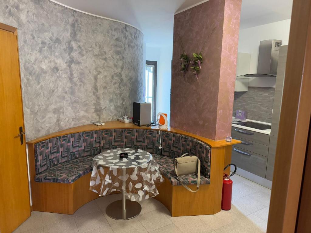 a room with a bench with a table and a kitchen at Michelle Luxury Living in centro a Gorizia in Gorizia