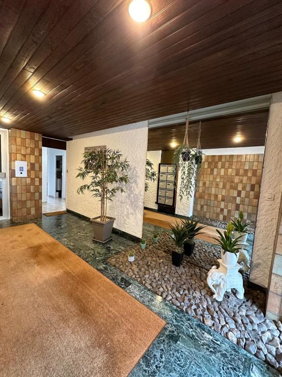 un salon avec un canapé et quelques plantes dans l'établissement Lourdes, à Nevers